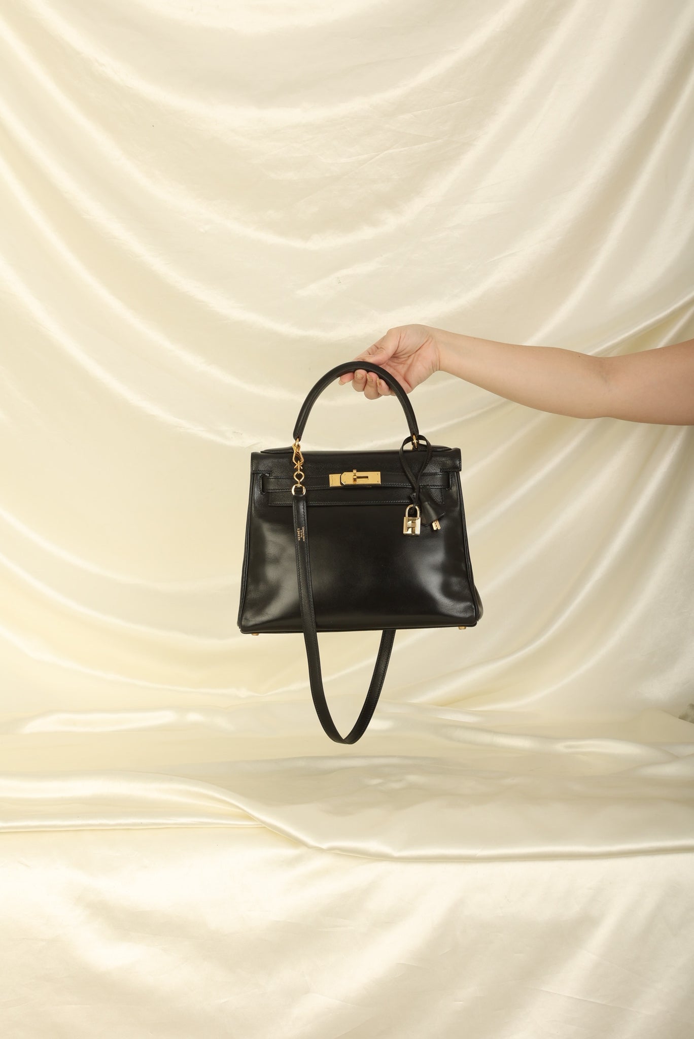 Lot - Hermes – a black leather Box Kelly Retourne 28 bag